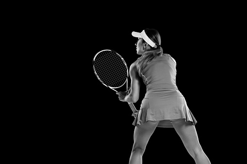 Woman playing tennis on court hitting the ball