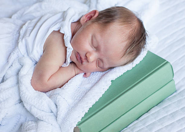 istock Newborn Baby Girl Sleeping on a Stack of Books 161863684