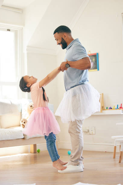 istock Ballet dance, father and happy kid play pretend game, learning routine steps and enjoy home fun, support and bond. Holding hands, Halloween fantasy costume and ballerina child and family dad playing 1618649772