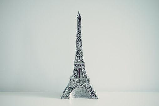Eiffel tower model on table white wall background. Travel, design decoration concept.