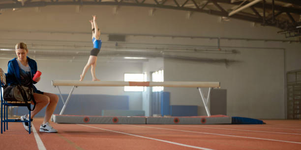 istock Gymnast woman sitting on bench 1618664016