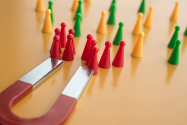 istock Horseshoe magnet attract red people from crowd on yellow background. 1618670334