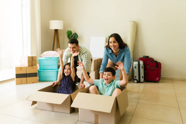 istock Parents and kids racing on boxes while moving into their new home 1618679203