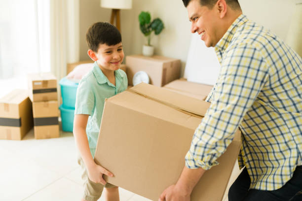 istock Hispanic dad and kid unpacking boxes at the new house 1618684210