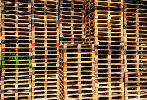A close-up of large stacks of used wooden pallets.