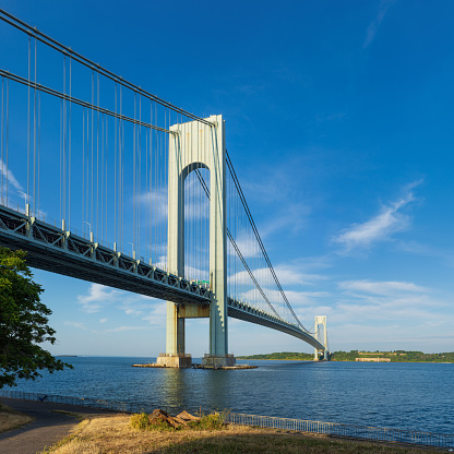 High resolution stitched image of the Verrazano-Narrows Bridge on a spring morning. The bridge connects boroughs of Brooklyn and Staten Island in New York City. It was built in 1964 and is the largest suspension bridge in the USA. Historic Fort Wadsworth is next the bridge foot. Canon EOS 6D full frame censor camera. Canon EF 50mm f/1.8 II Prime Lens. 1:1 Image Aspect Ratio. The image was stitched from 2 rows of images. This image was downsized to 50MP. Original image resolution is 95.5MP or 9776 x 9776 px.