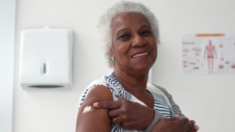 Portrait of a senior woman showing that she has been immunized with the vaccine