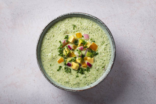 Green vegetable cold cream soup with herbs styled and decorated in rustic bowl