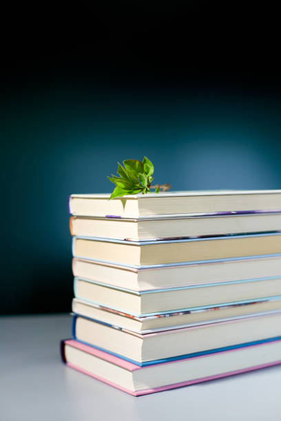 istock Stack of books with branch green leaves, World book day 1618778355