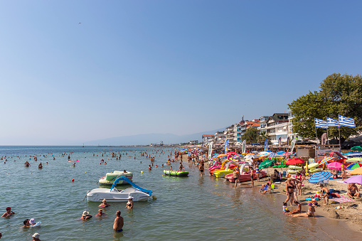 Paralia Katerinis, Pieria, Greece, July 18th, 2023: Aegean sea beach with swimming and sunbathing people