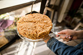 high angle view on traditional honey cake on plate in female hand. Blurred background.