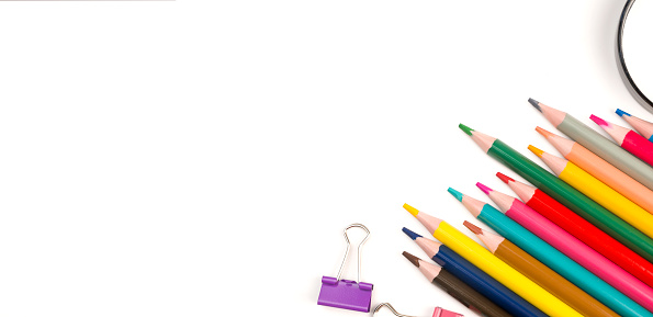 Back to school flat lay with colorful pencils,magnifier and paper clips. Banner with place for text