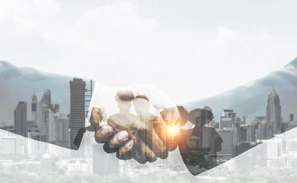 istock Handshake in close-up with a cityscape in the backdrop.teamwork idea. two exposures. 1618810819