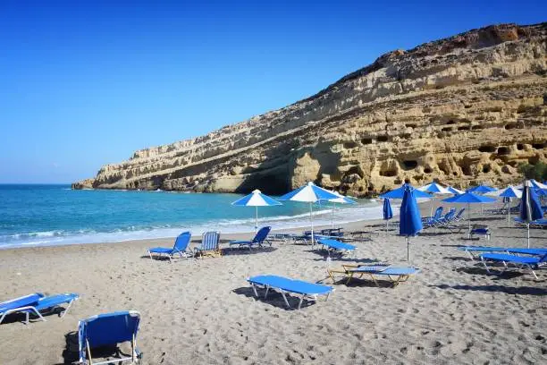 Matala, Crete - beach view with hippie caves in background.