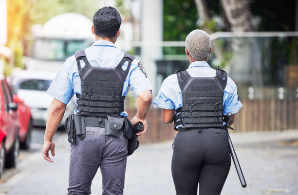 Police, people or walking in city for safety, law enforcement and urban patrol from the back. Man, woman and team of public service cops, metro security guard or protection in street together outdoor Police, people or walking in city for safety, law enforcement and urban patrol from the back. Man, woman and team of public service cops, metro security guard or protection in street together outdoor public service employee stock pictures, royalty-free photos & images