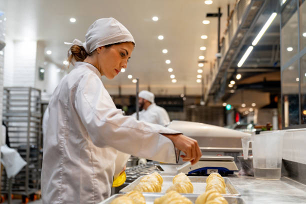 istock Woman working at a bakery making croissants 1618826216