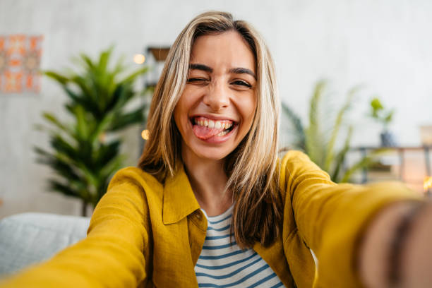 istock Cheerful Young Woman Taking Selfie At Home 1618839621