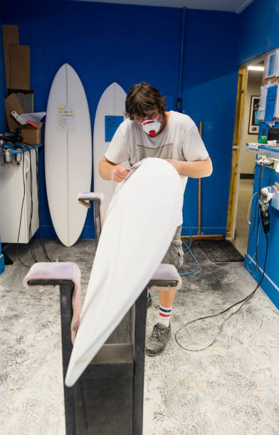 istock Professional surf shaper in action sanding a shape in his workshop 1618856088
