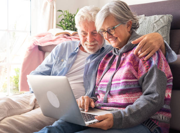 istock Smiling senior couple at home using together a laptop computer. Two elderly retirees enjoying free time and technological devices 1618869550