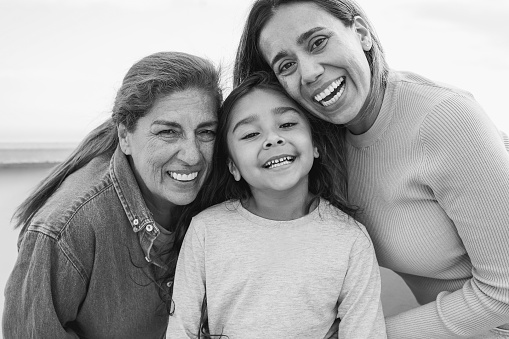 Portrait of happy multigenerational latin family smiling on camera - Grandmother, daughter and granddaughter love concept
