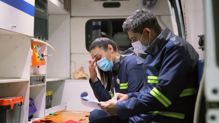 Exhausted paramedic team managing paperwork