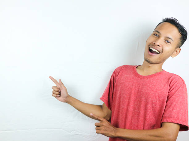 istock Asian man point to present an empty space of content. Advertising model concept. 1618896728