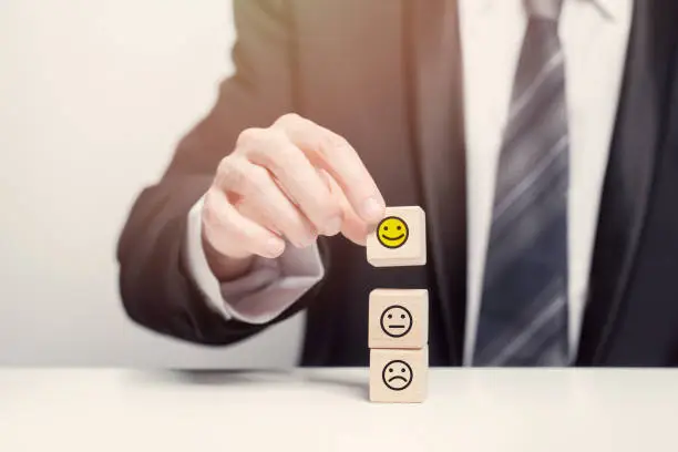 Photo of Business customer feedback concept, wooden blocks, emotions, hand in suit