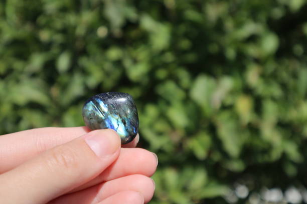 istock Labradorite stone in hand outdoor. 1618930467