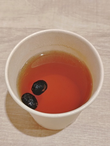 transparent cup with black tea the top view on a white background