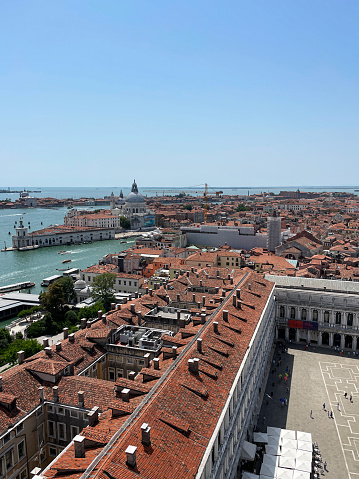 Stock photo showing close-up view of Piazza San Marco (St. Mark's Square), Museo Correr, Giardini Reali di Venezia (Royal Gardens of Venice), Le Zitelle, al freco dining cafes and terracotta rooftops of residential buildings viewed from St Mark's Campanile (bell tower).