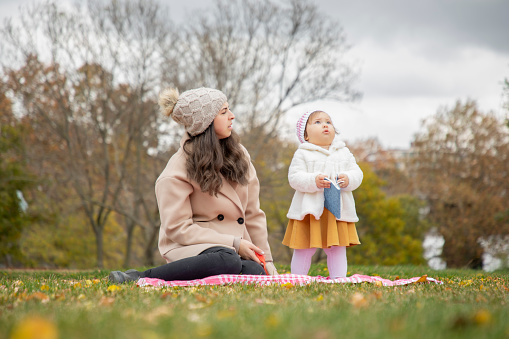 Mother and baby girl spending time alone in nature in autumn