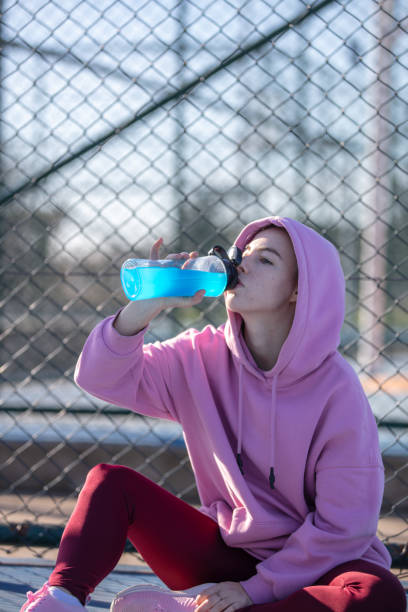 istock Young female athlete is drinking energy drink. 1619000452