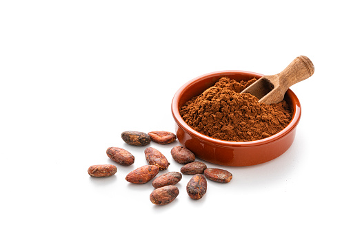 Cocoa beans and cocoa powder isolated on white background. High resolution 42Mp studio digital capture taken with Sony A7rII and Sony FE 90mm f2.8 macro G OSS lens