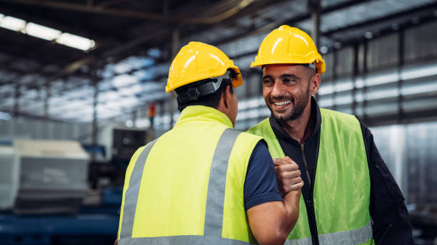 istock Team Engineer is shaking hands. Industrial worker in the factory. Engineer is maintaining in the warehouse. 1619031747