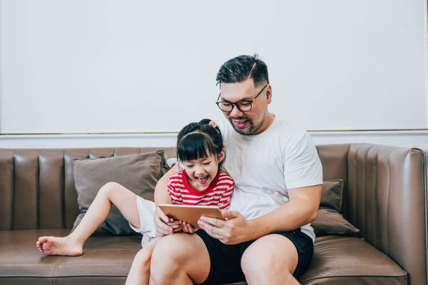 istock Girl and Dad Playing Tablets Together 1619045400