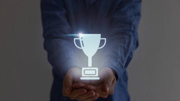 istock Close up man hands holding champion golden trophy isolated over background. 1619051299