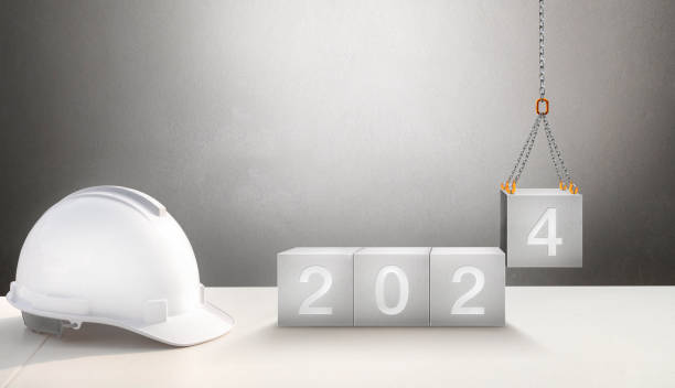 Happy New Year 2024 Construction and Industry. White Helmet and a numbered concrete cube on the desk of an engineer or construction worker. building with Cranes construction concept.