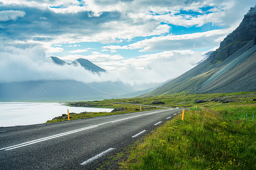 Picturesque view from roadside with valley mountain with foggy on the road during summer in sunny day at Iceland