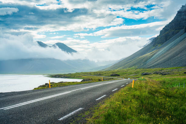 View from roadside with valley mountain with foggy on the road during summer in sunny day Picturesque view from roadside with valley mountain with foggy on the road during summer in sunny day at Iceland car-on-city-road-side-view stock pictures, royalty-free photos & images