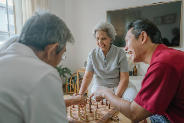istock Asian senior playing Chess together with friends at home 1619081976