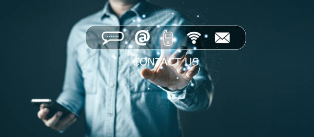 istock Businessman using smartphone and computer laptop with virtual screen contact icons(address,phone,wifi,email),Contact us and Customer support hotline people connect. 1619085224