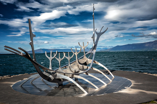 July 12, 2023 - Reykjavik, Iceland.  The Sun Voyager (Sólfarið) is a large steel sculpture of a ship, located on the road Sæbraut, by the seaside of central Reykjavík. The work is one of the most visited sights in the capital, where people gather daily to gaze at the sun reflecting in the stainless steel of this monument.