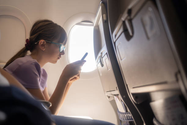 istock Girl playing with tablet during a flight looking very happy 1619144241