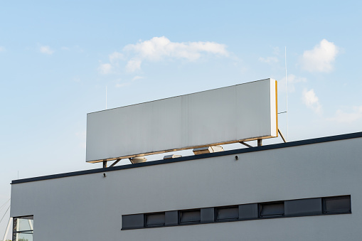 Big empty signboard on an industrial building. Template for a sign or logo on a rooftop. A company name can be on the mockup.