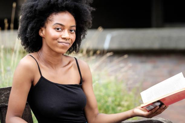 istock Smiling woman holding a book and looking at camera. 1619181563