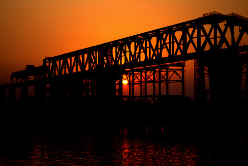 Sunset under a bridge at a river bank of Bangladesh