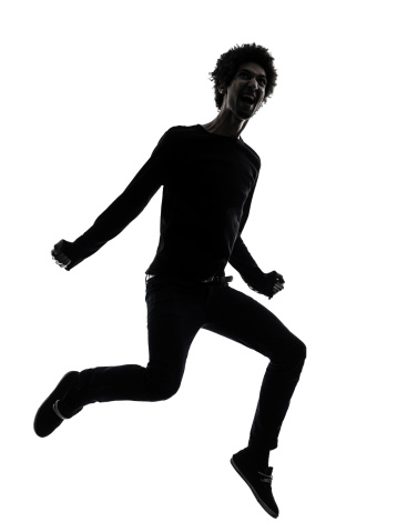 one african handsome young man jumping screaming  in silhouette studio on white background