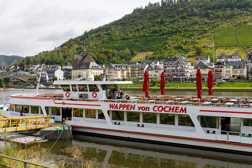 Cochem, Germany - August 8th 2023: Ferry boat at Cochem \n\nCochem is the seat of and the biggest town in the Cochem-Zell district in Rhineland-Palatinate, Germany. With just over 5,000 inhabitants, Cochem falls just behind Kusel, in the Kusel district, as Germany's second smallest district seat. Since 7 June 2009, it has belonged to the Verbandsgemeinde of Cochem. \nSource: Wikipedia