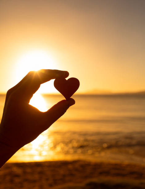 istock Woman holding heart at sunset. 1619235993