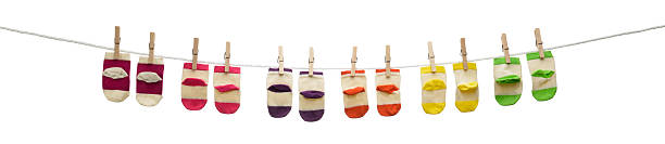 Striped sock hanging on a clothesline against a blue sky background.